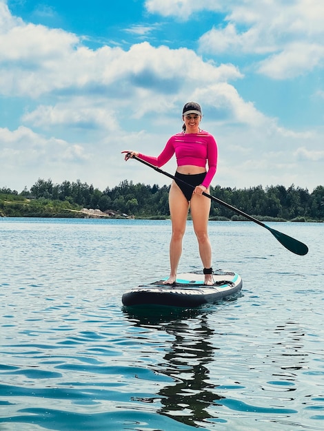 Mulher de pé a bordo de verão atividades de lago de água