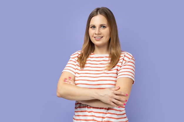 Mulher de pé com as mãos postas de bom humor expressando felicidade