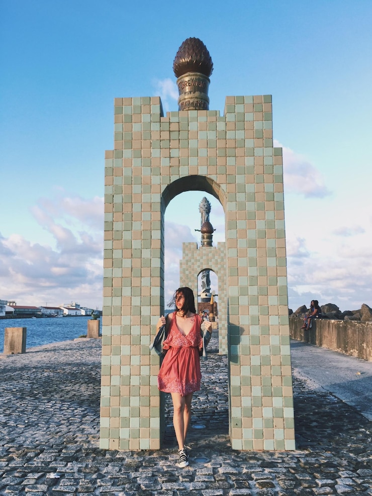 Foto mulher de pé contra o portão da cidade