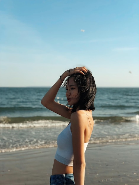 Mulher de pé na praia contra o céu