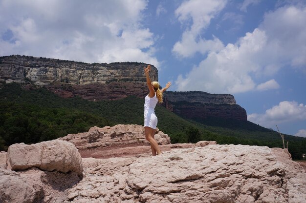 Foto mulher de pé na rocha contra o céu