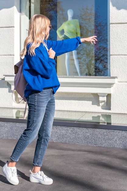 mulher de pé na vitrine aponta para a mão