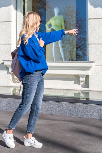 Mulher de pé na vitrine aponta para a mão