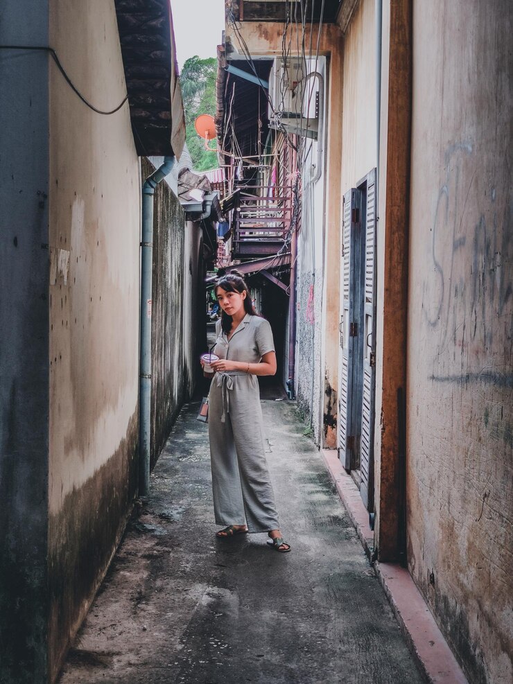 Foto mulher de pé no beco no meio dos edifícios