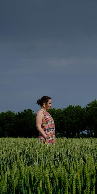 Mulher de pé no campo contra o céu