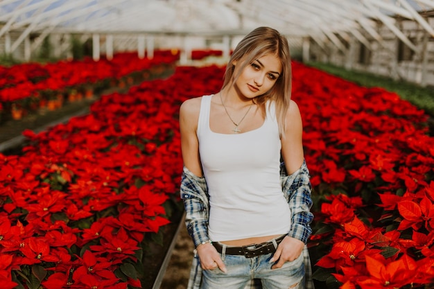 Mulher de pé no jardim botânico verde cheio de vegetação Retrato de noiva loira atraente em um vestido de noiva no fundo de vegetação