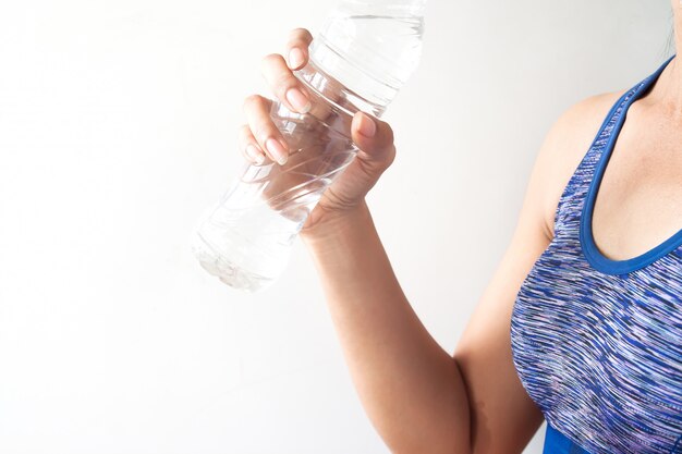 Foto mulher de pele bronzeada asiática fitness com suor segurando a garrafa de água