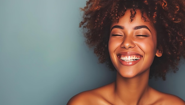 Foto mulher de pele escura feliz com um grande sorriso em um fundo azul o conceito de positividade e beleza