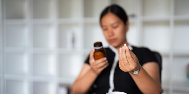 Mulher de perto segurando um comprimido na mão com água sentindo-se doente Mulher vai tomar analgésico de dor de cabeça analgêsico cuidados de saúde medicina tratamento terapia paciente doença conceito de doença