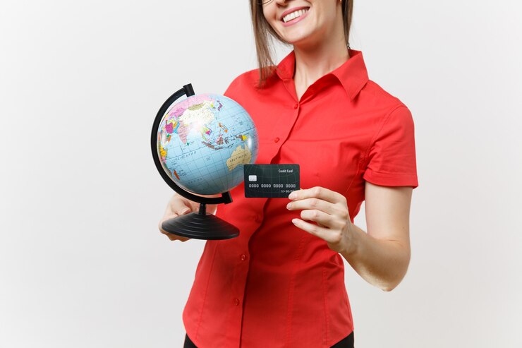 Foto mulher de professor de negócios foto recortada em óculos de saia de camisa vermelha, segurando o globo e o cartão de crédito, isolado no fundo branco. ensino de educação na universidade do ensino médio, turismo, conceito de estudo no exterior.