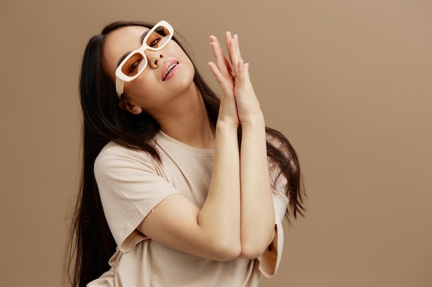 Mulher de retrato em camiseta de óculos de sol posando estilo moderno de fundo bege