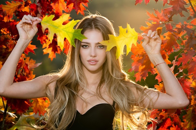 Mulher de romance de outono com modelo feminino de folhas em dia de sonho de folhagem e porta externa de beleza de estilo de vida