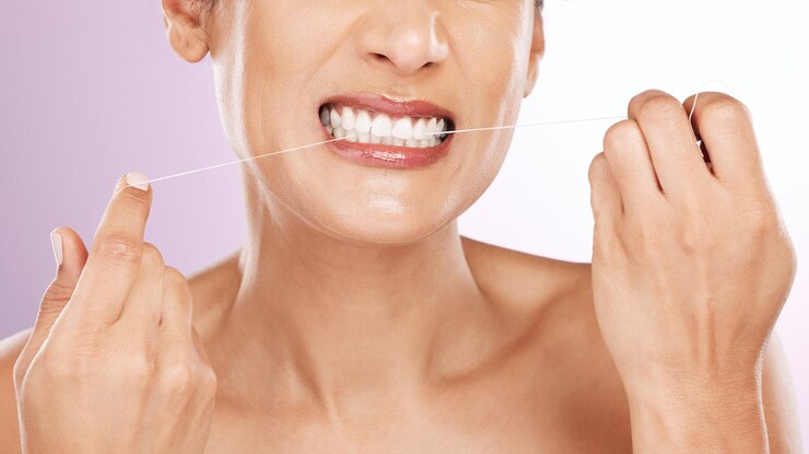 Foto mulher de rosto e dentes de fio dental para limpeza de higiene ou cuidados com os dentes em estúdio isolado em um fundo roxo saúde bucal hálito fresco ou modelo feminino maduro com fio dental ou fio para bem-estar