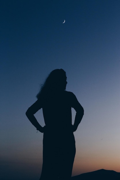 Foto mulher de silhueta de pé contra o céu limpo