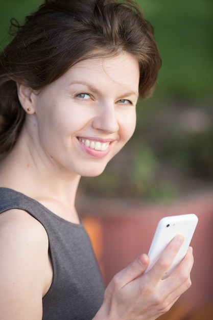 Mulher de sorriso com um smartphone