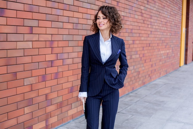 Mulher de sucesso vestida com um terno elegante posando em frente ao escritório Líder de negócios feminina