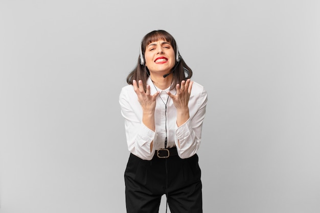 Mulher de telemarketing parecendo desesperada e frustrada, estressada, infeliz e irritada, gritando e gritando