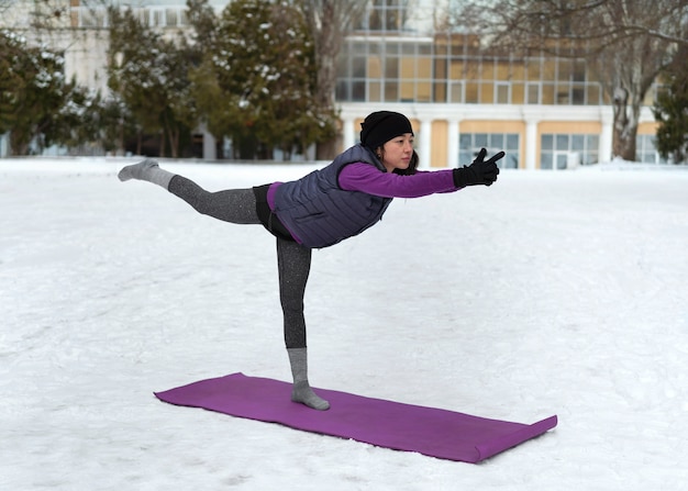 Foto mulher de tiro completo fazendo ioga em clima frio
