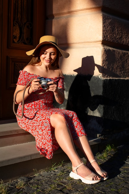 Foto mulher de tiro completo segurando câmera fotográfica