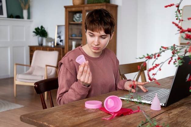 Foto mulher de tiro médio com copo menstrual rosa