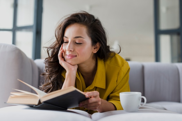 Mulher de tiro médio com livro e copo