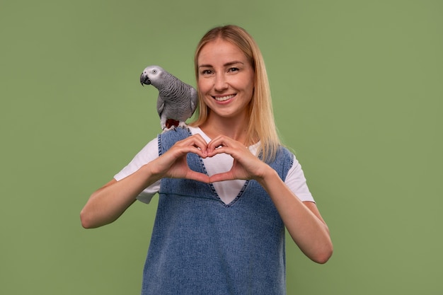 Mulher de tiro médio com papagaio em estúdio