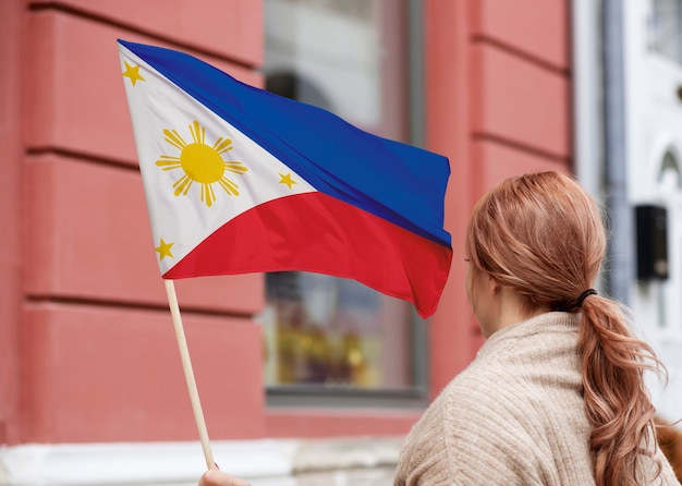 Foto mulher de tiro médio segurando bandeira filipina