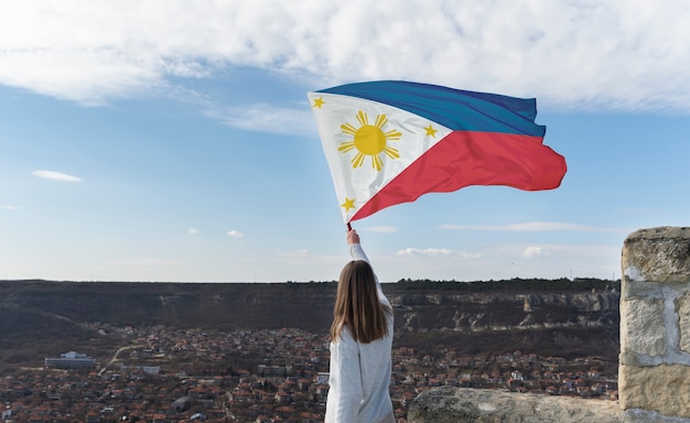 Foto mulher de tiro médio segurando bandeira filipina