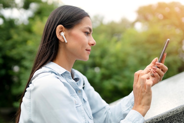 Mulher de tiro médio segurando o telefone