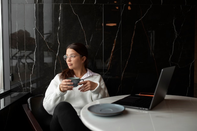 Foto mulher de tiro médio sentada à mesa