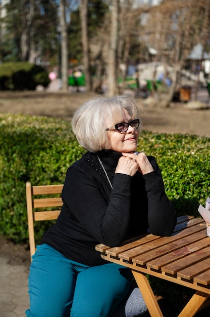 Mulher de tiro médio sentada à mesa