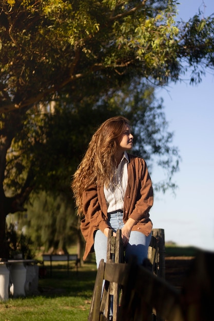 Foto mulher de tiro médio sentada na cerca