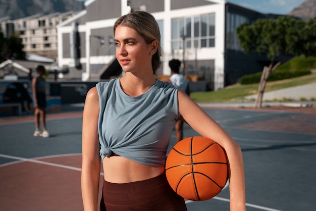 Mulher de tiro médio treinando para basquete