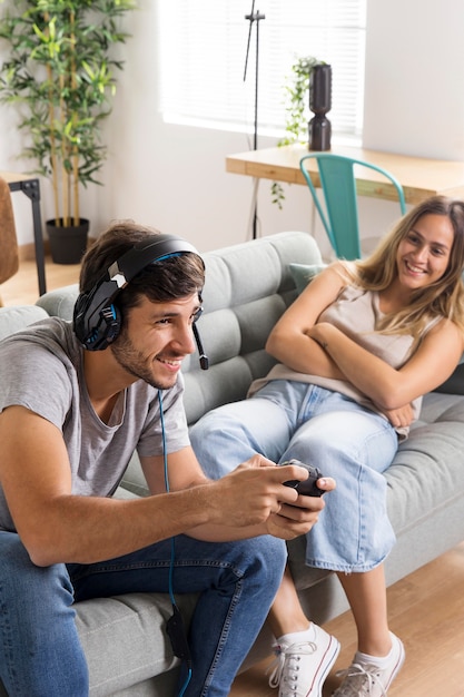 Mulher de tiro médio vendo homem jogar jogo