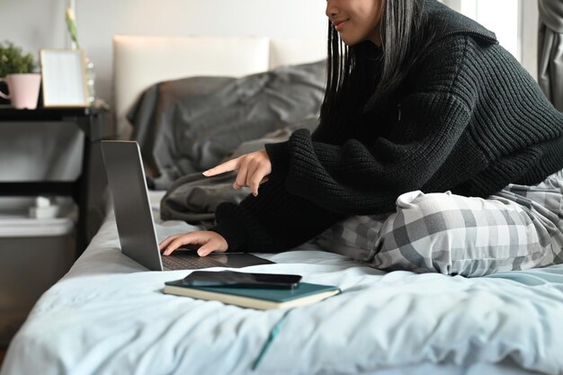 Mulher de tiro recortado usando laptop no quarto em casa Pessoas e conceito de tecnologia