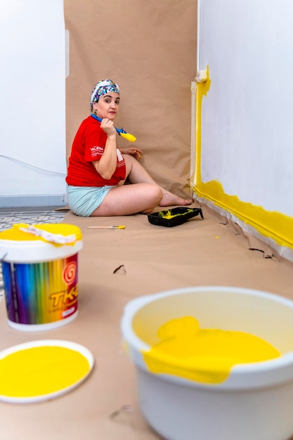 Foto mulher de transformação de casa em sua meia-idade pintando paredes de amarelo