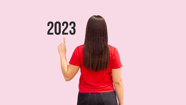 Mulher de trás apontando para 2023