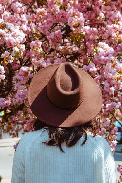 Mulher de trás olhando para a árvore de sakura em flor