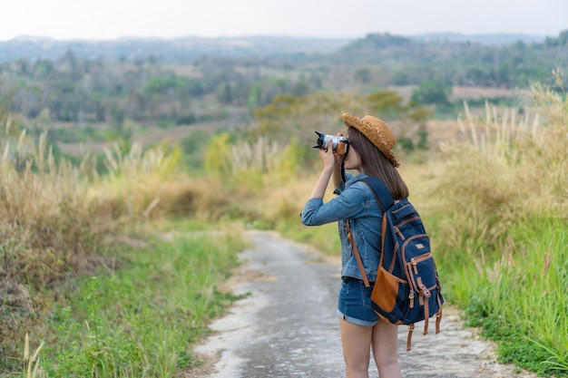 Mulher de turista tirando foto com a câmera na natureza