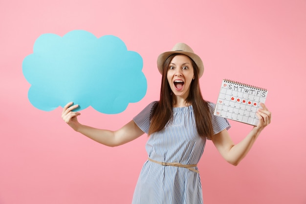 Mulher de vestido azul, chapéu segurando vazio em branco say nuvem, balão, calendário de períodos femininos, verificando dias de menstruação isolados no fundo. conceito ginecológico de saúde médica. copie o espaço.