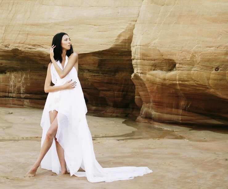 Foto mulher de vestido branco dançando no deserto