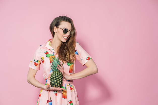 Mulher de vestido colorido, segurando um abacaxi