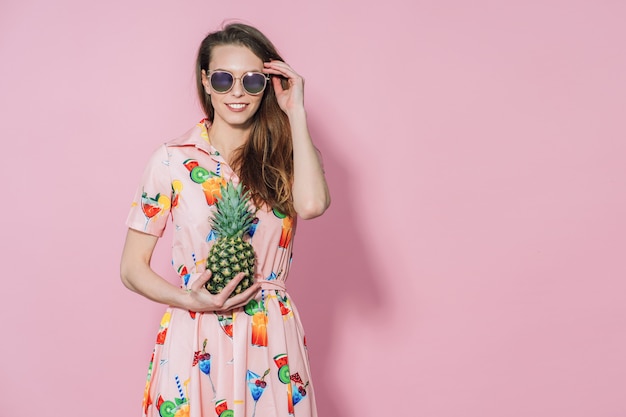 Mulher de vestido colorido, segurando um abacaxi