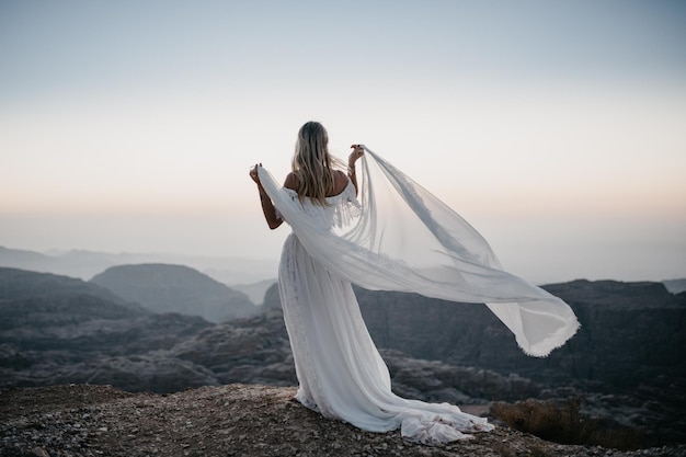 Mulher de vestido de pé na paisagem contra o céu