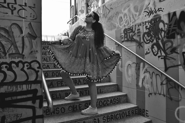 Foto mulher de vestido de pé nas escadas da cidade