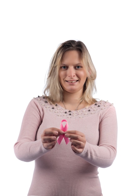 Foto mulher de vestido rosa segurando uma fita de câncer de mama