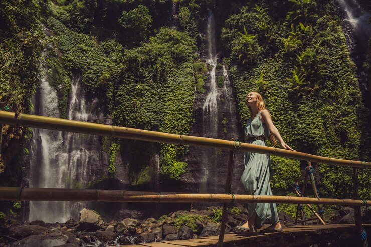 Foto mulher de vestido turquesa nas cachoeiras de sekumpul nas selvas na ilha de bali indonésia bali travel concept