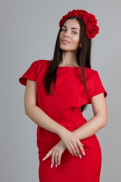 Mulher de vestido vermelho com uma coroa de rosas na cabeça