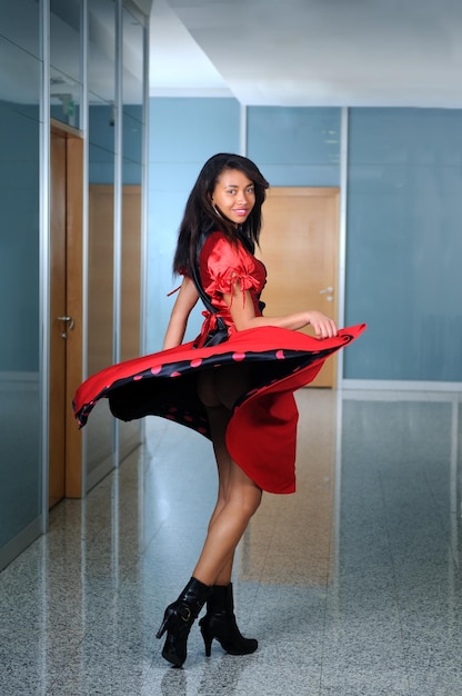 mulher de vestido vermelho dançando no interior