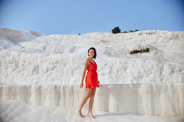 Mulher de vestido vermelho em travertinos brancos, pamukkale